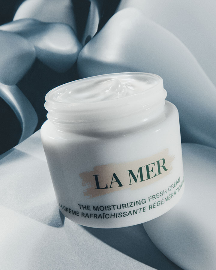 The Moisturizing Fresh Cream with lid off showcasing product texture in a dramatically lit setting